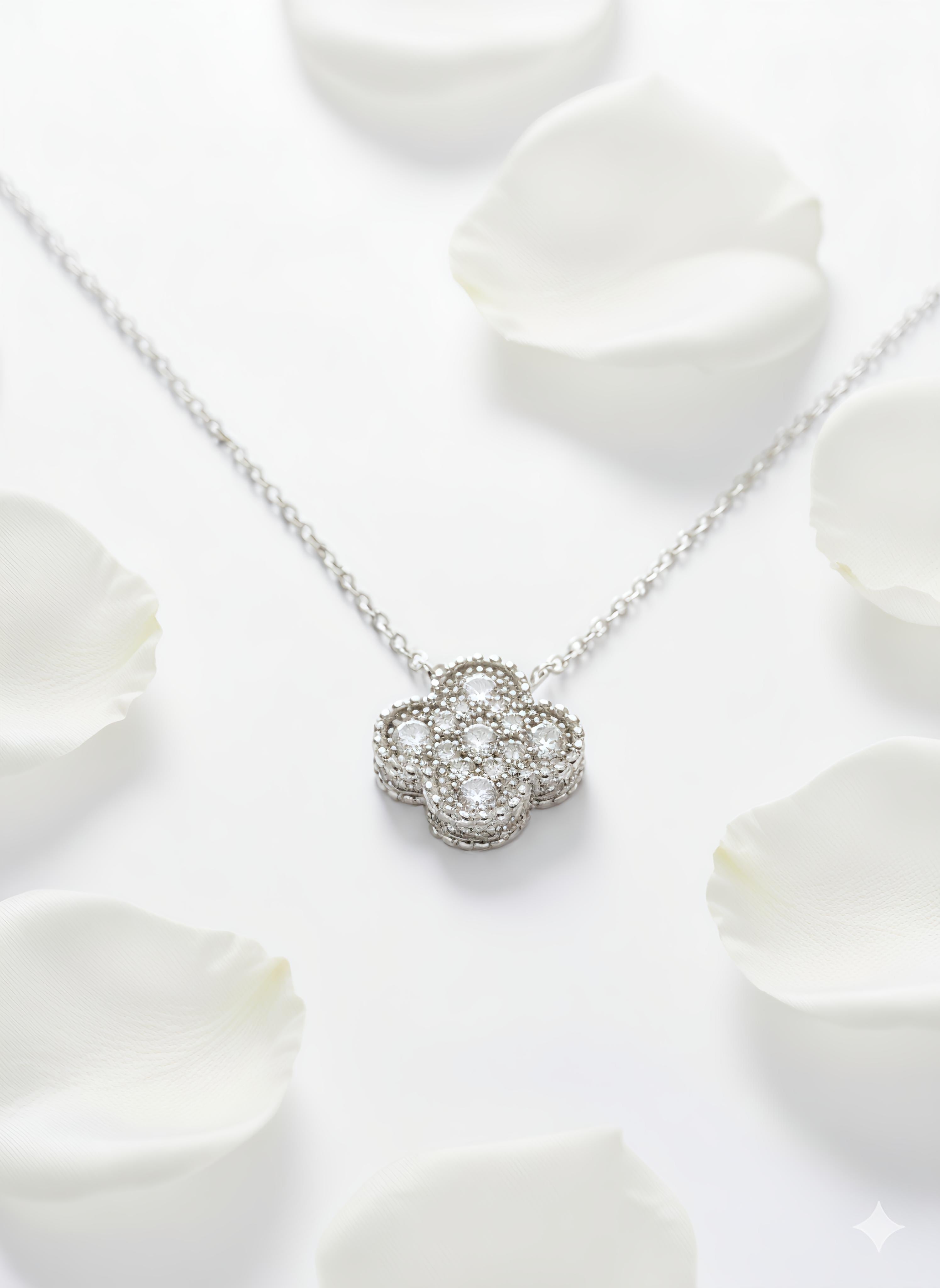 Silver necklace with a floral pendant on white rose petals