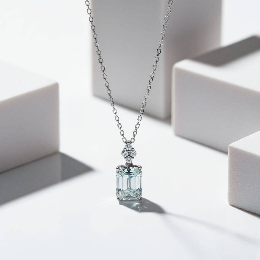Silver necklace with a green gemstone pendant on a white background