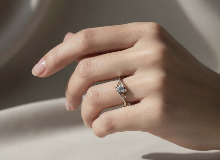 Hand wearing a diamond ring on a neutral background